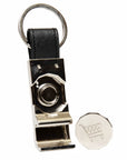Metallic whistle with black leather strap and visible brand logo on a white background