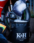 Person cleaning a motorcycle with a K&H collapsible bucket and sponge.