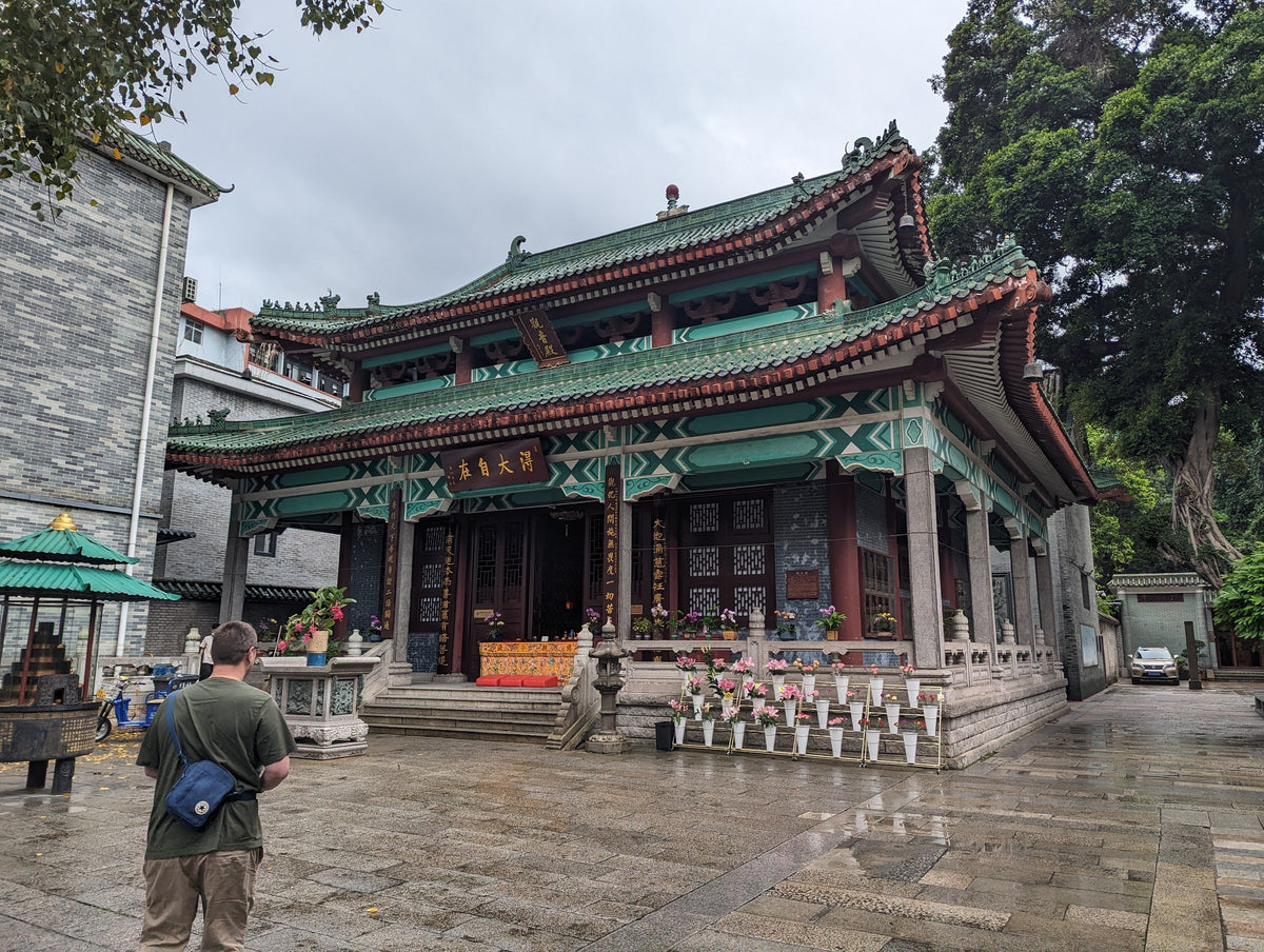 Traditional Chinese temple in Guangzhou with green tiled roofs and ornate pillars