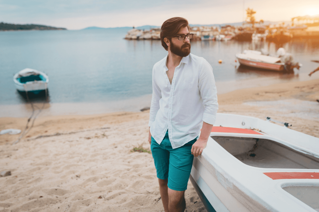 Man on the beach by boats