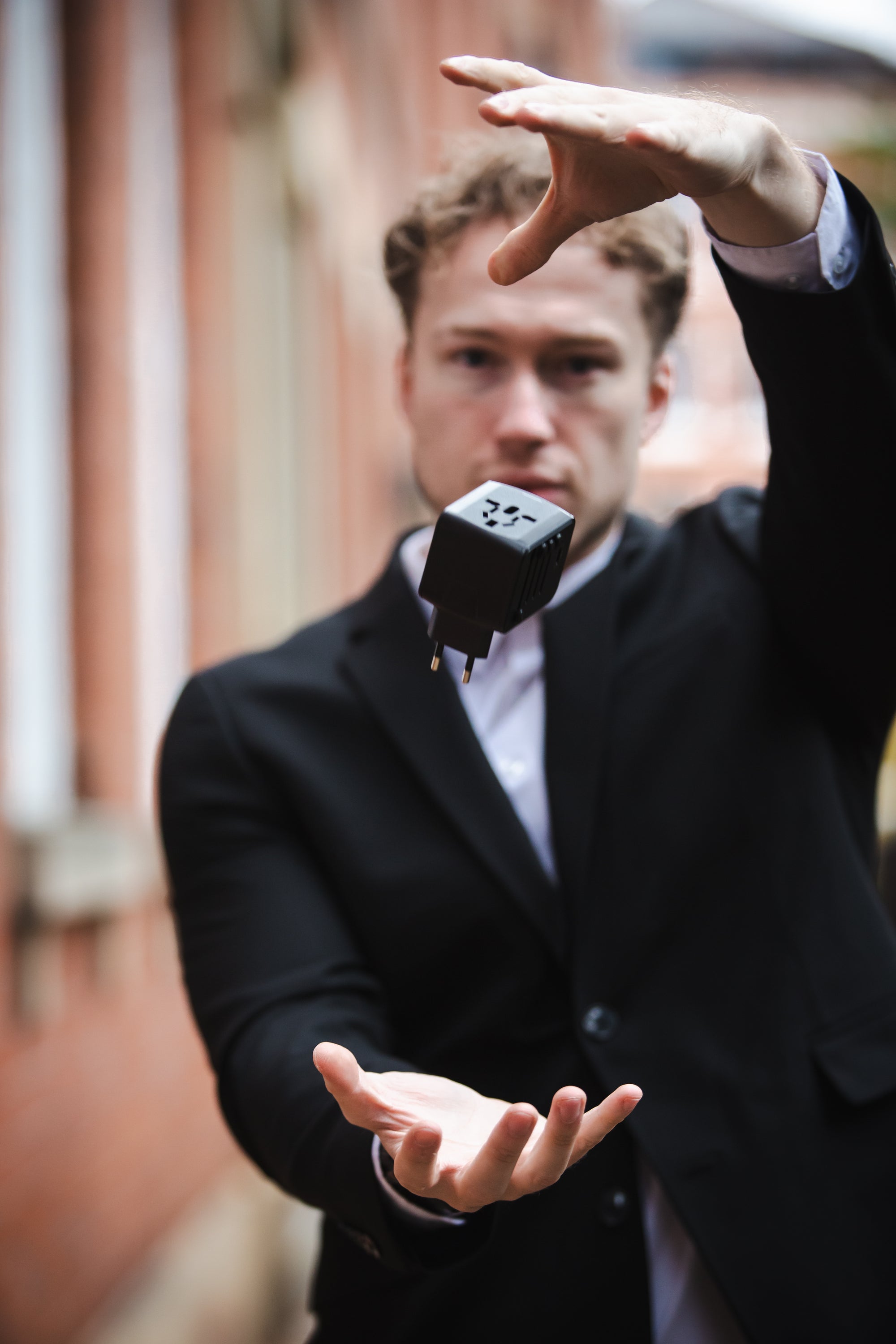 Black rectangular power adapter with multiple plug prongs and a minimalist design.