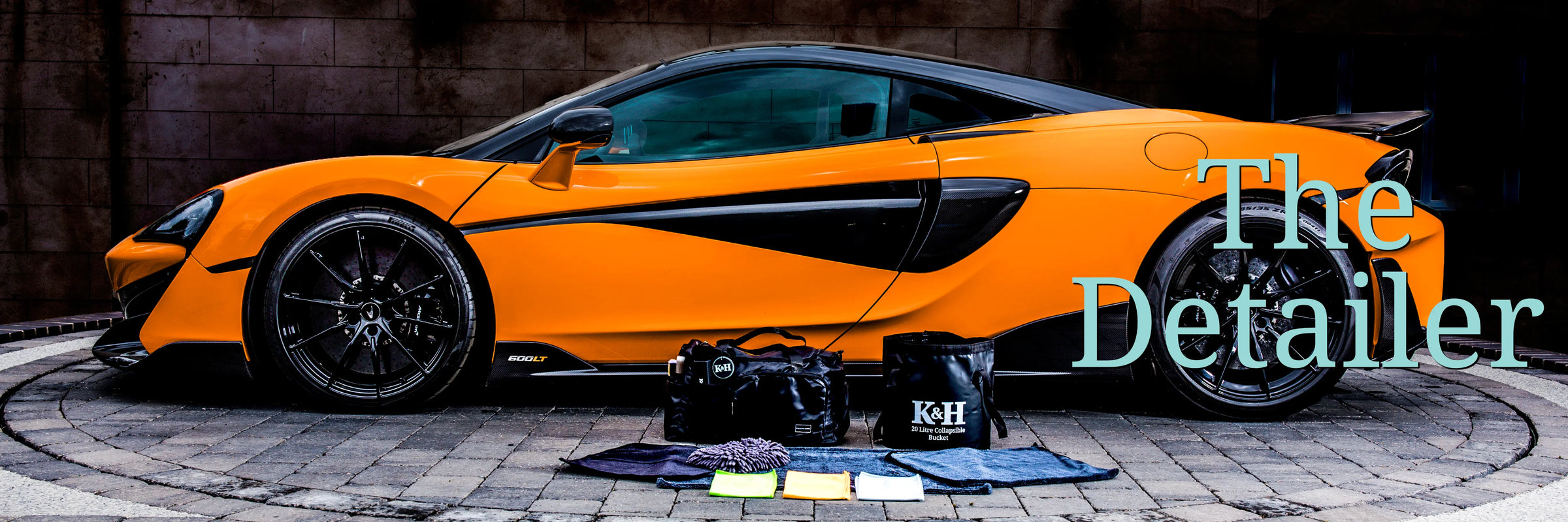 Orange sports car with kingsley and harper car detailing kit on a driveway, featuring 'The Detailer' text.