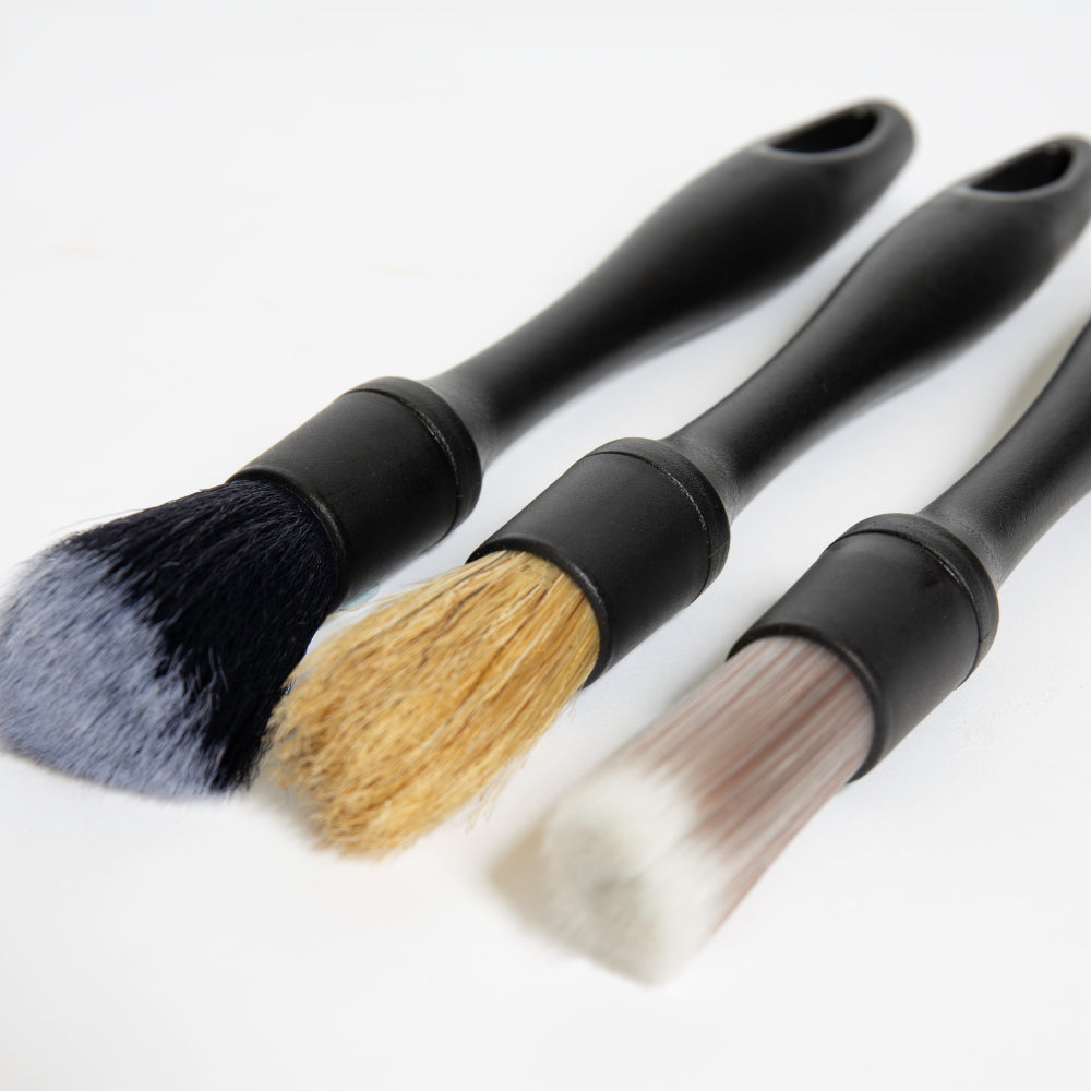 Three cleaning brushes with different bristle types included in The Detailer Car Cleaning Set on a white background